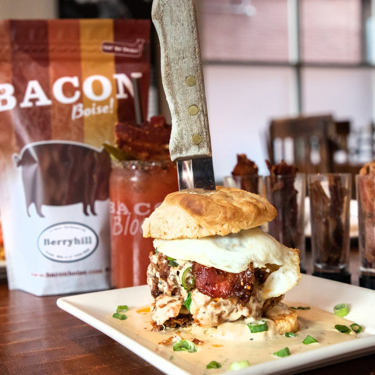 Bacon biscuit sandwich on a plate with a bag of bacon in the background