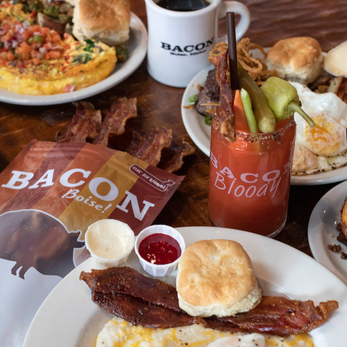 Breakfast spread with eggs, bacon, biscuits, and coffee on a wooden table.