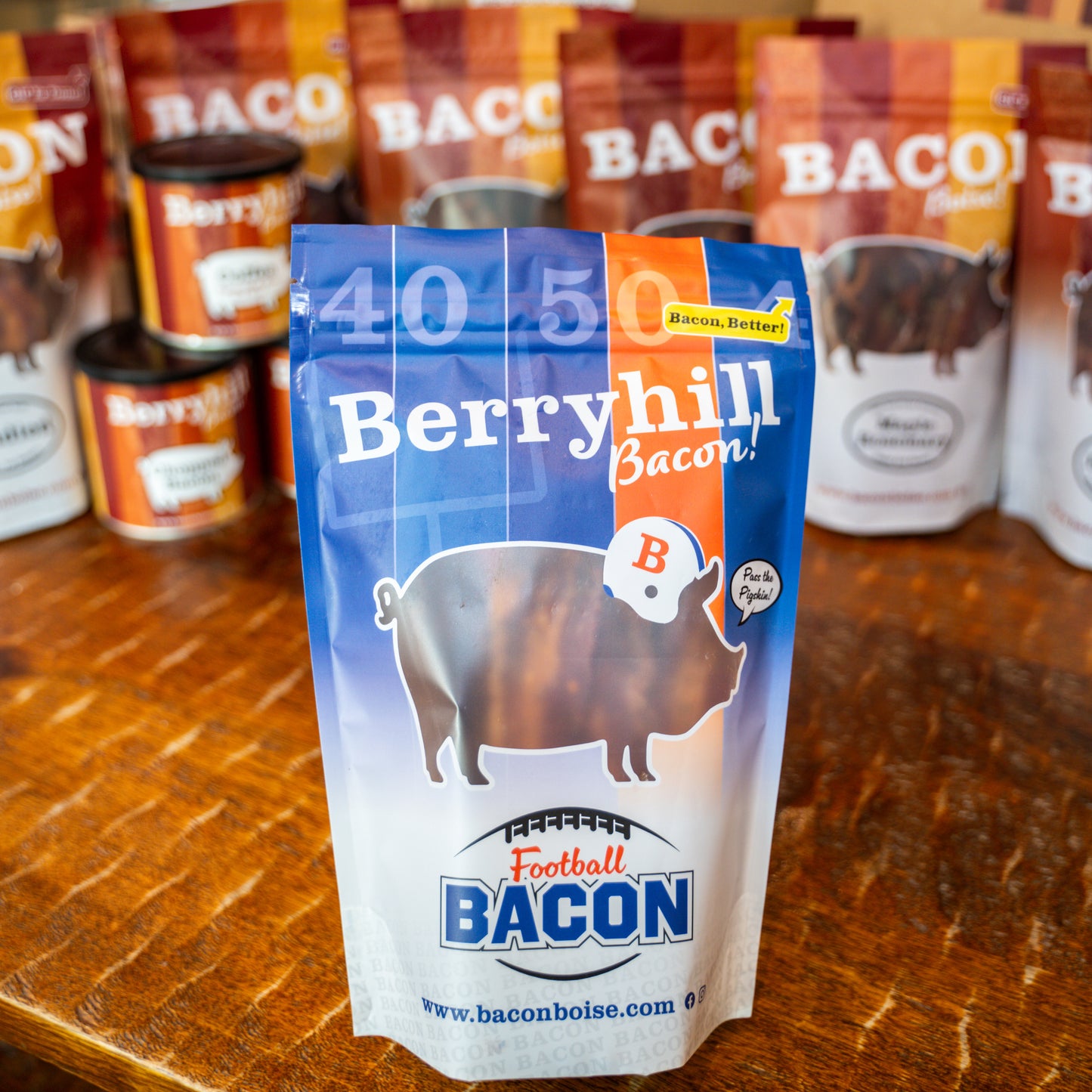 A pack of Berryhill Bacon with a blue and orange design, featuring an illustration of a pig and the text 'Football Bacon'. The packaging also displays the website 'www.baconboise.com'