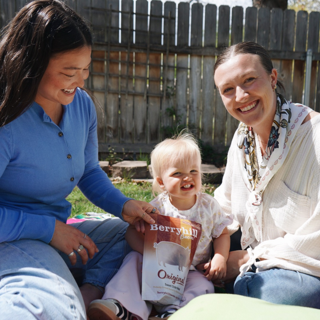 Two women and a child sitting outdoors with a Berryhill Originals package.