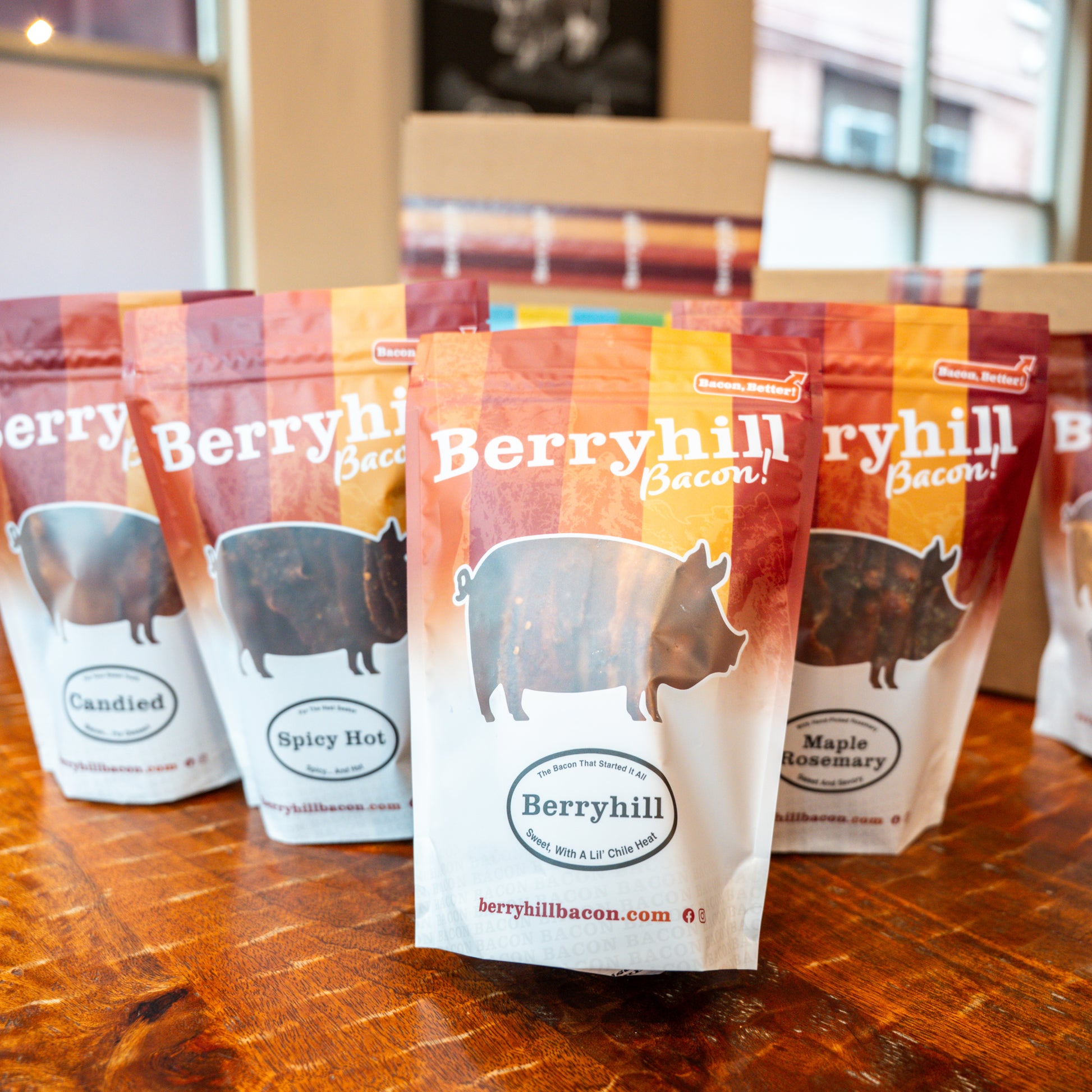 Multiple packages of Berryhill Bacon on a wooden surface