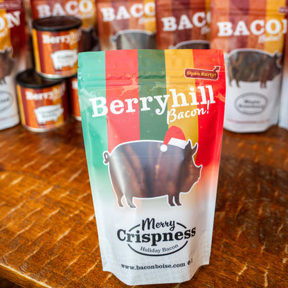 Berryhill Bacon Christmas-themed packaging on a wooden surface with other bacon packages in the background.