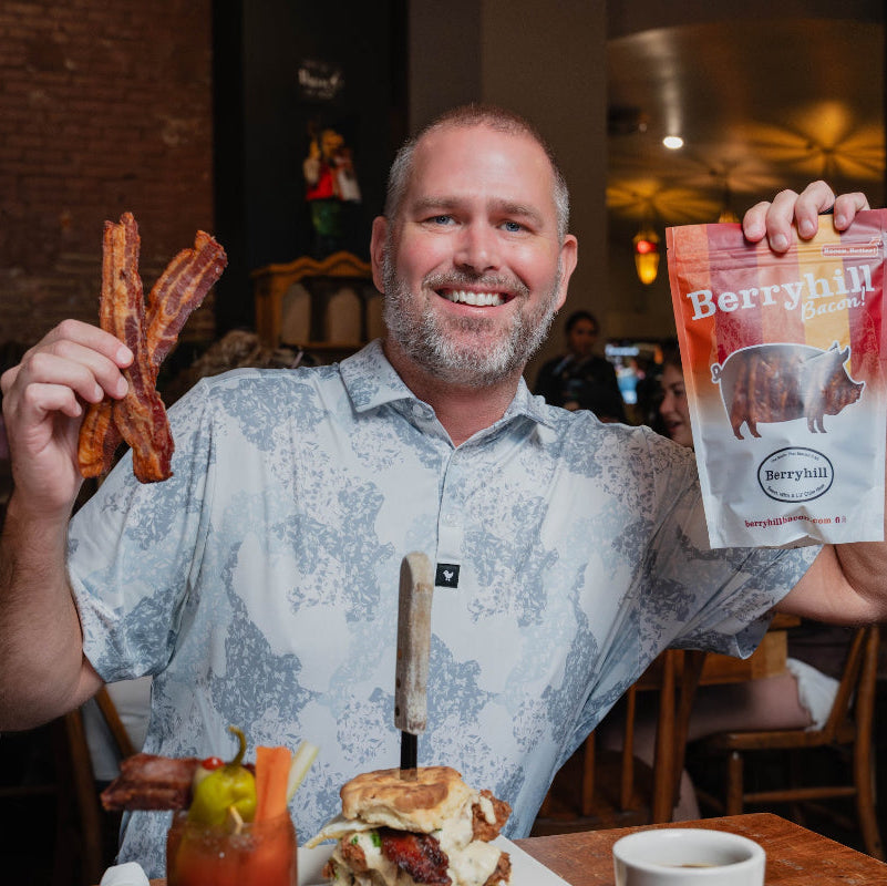 Man holding bacon and a package of 'Berrygut' in a restaurant setting