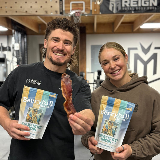 Two people holding packages of Berryhill Bacon in a gym setting
